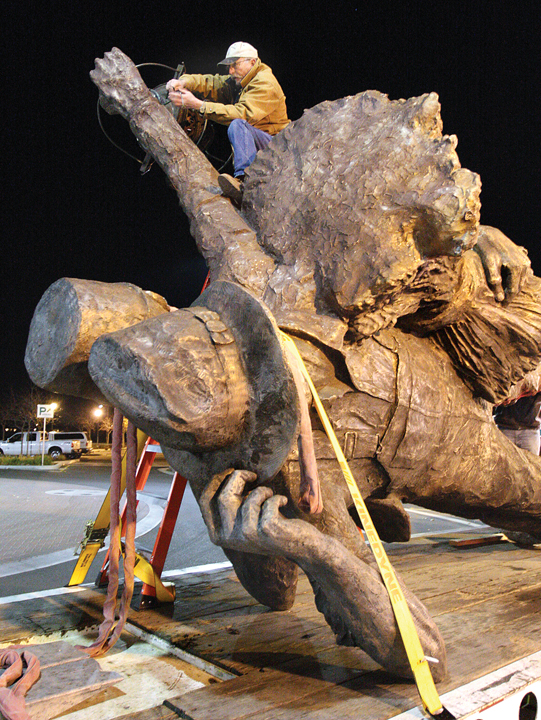 STATUE AT ROUNDABOUT3 (12-06-13)  Rowland Cheney runs electrical wiring through his ÒHarvest of ProgressÓ statue before it is raised over a platform at the center of the Sixth Street-Central Avenue roundabout late Dec. 5.  Glenn Moore/Tracy Press